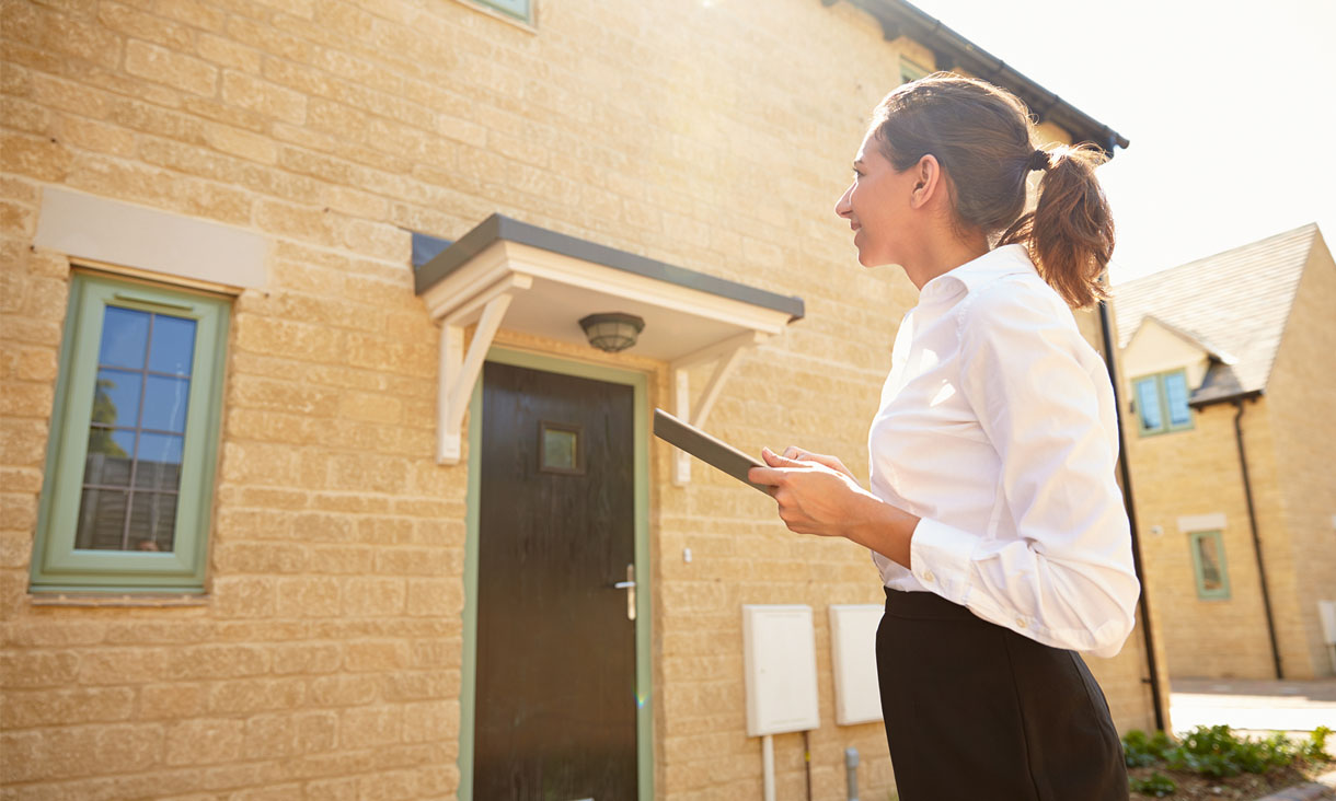 A property manager stands outside a property.
