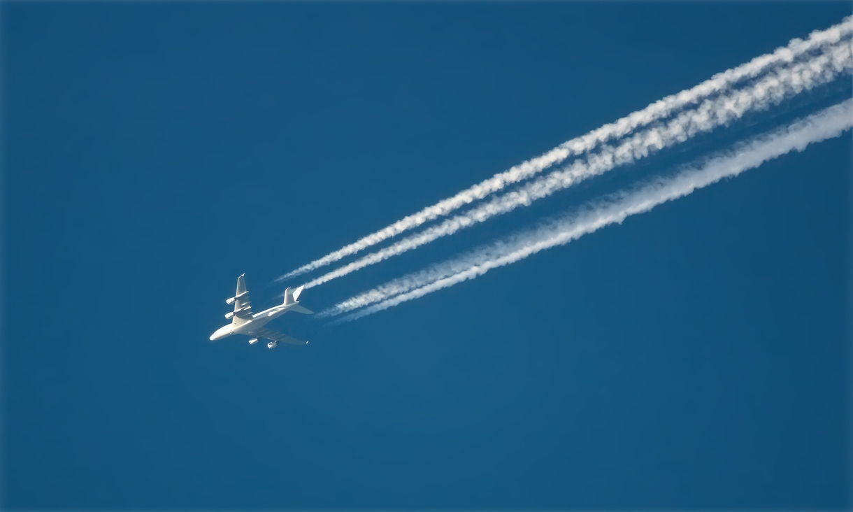 aircraft in blue sky with white vapour training behind