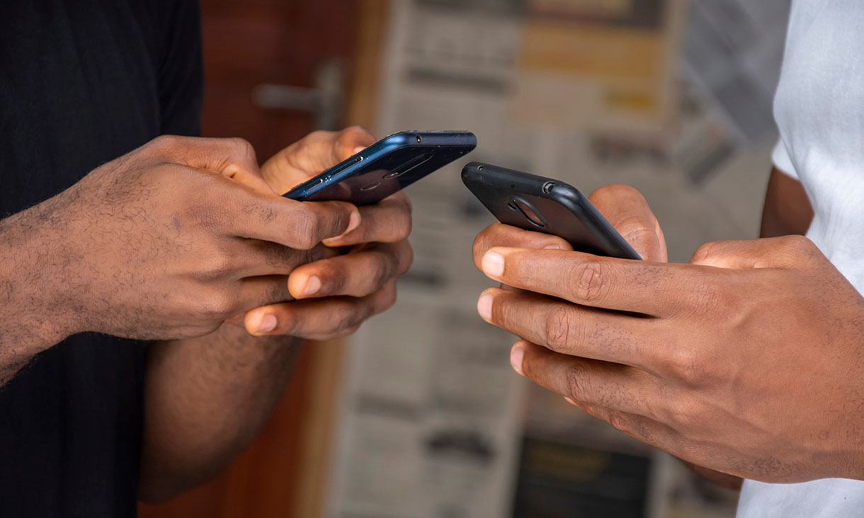 close up of two people's hands holding smartphones