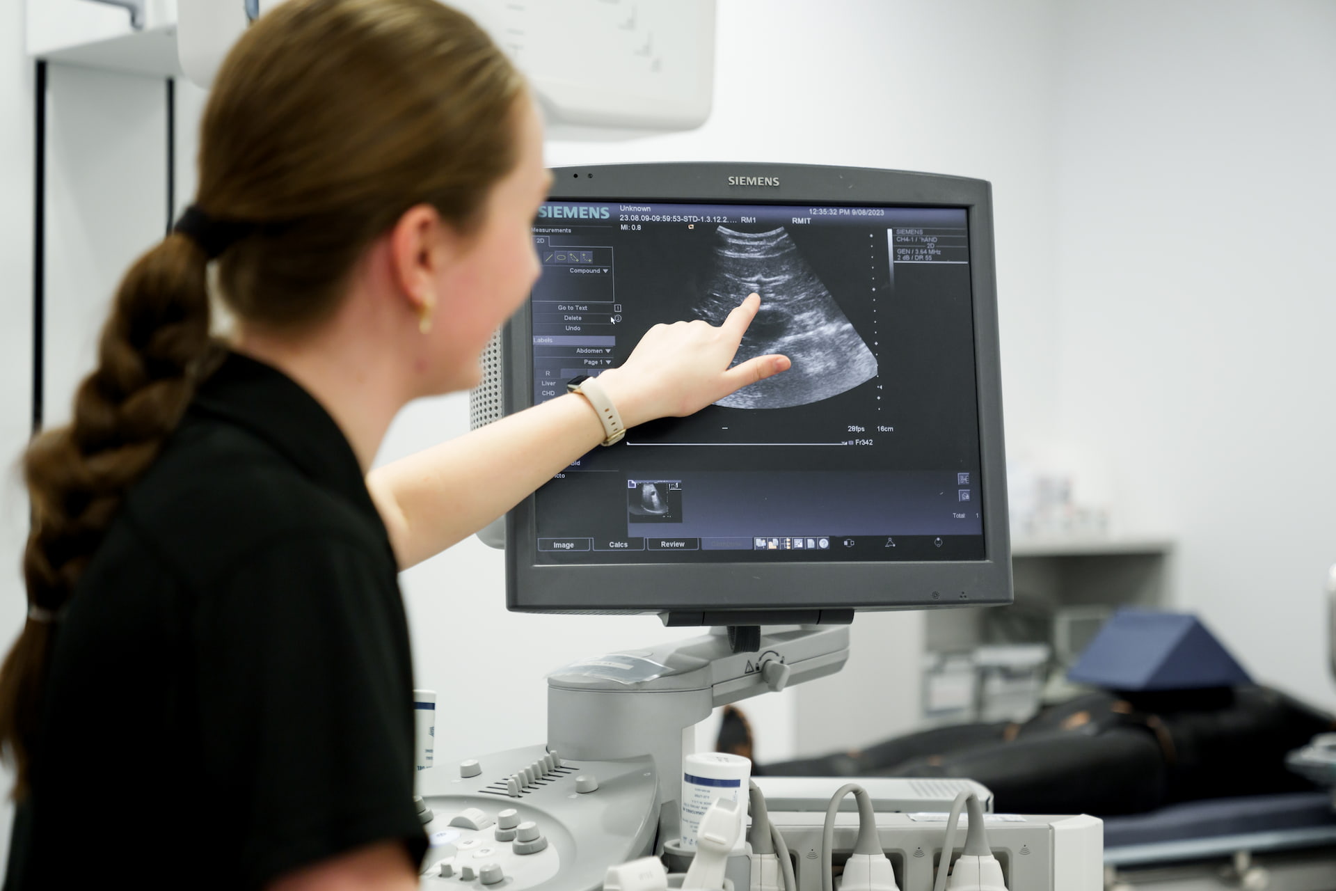 Person pointing at an ultrasound screen