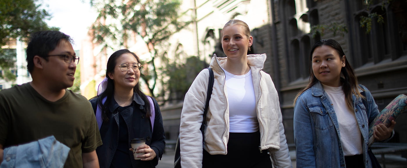 A group of RMIT students in discussion walking down Bowen Street, RMIT City campus