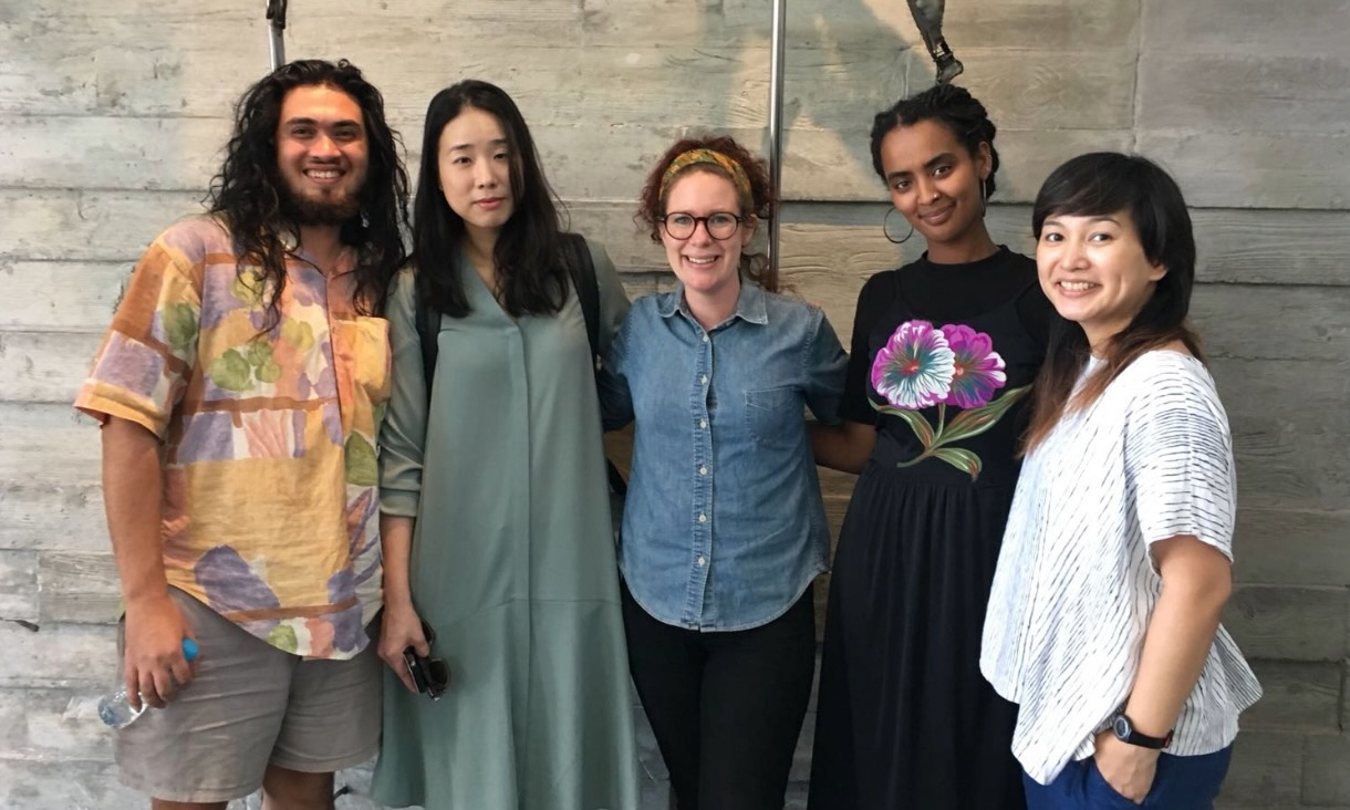 5 people standing together in front of wooden wall