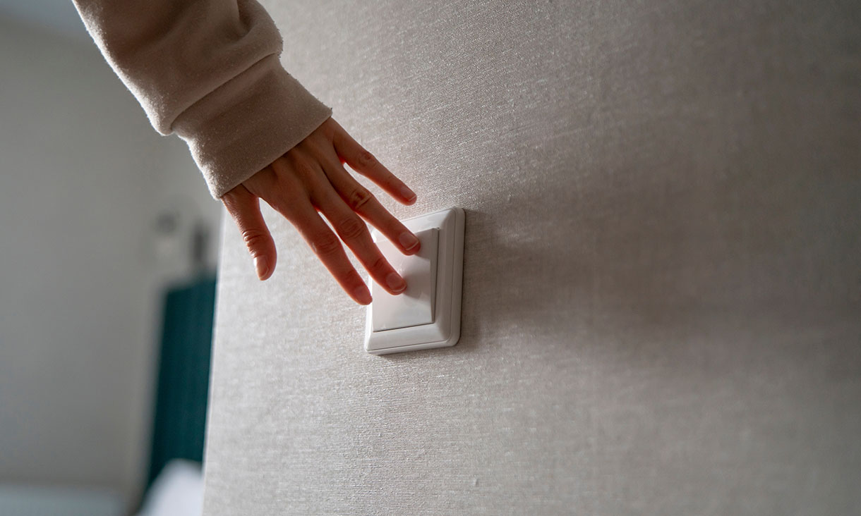 hand reaching for light switch