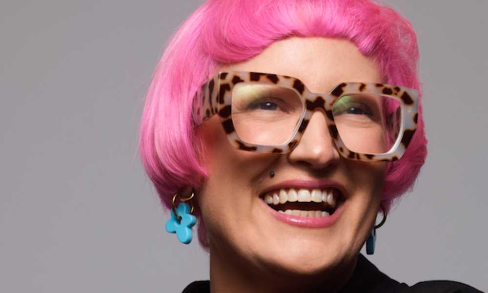 Woman with glasses and short pink hair