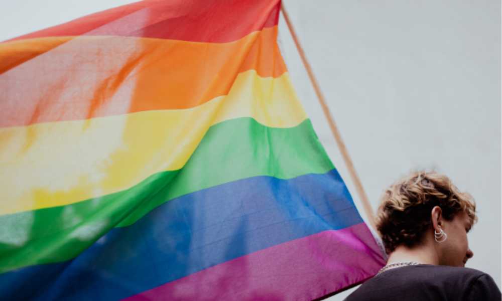 Person holding a rainbow flag