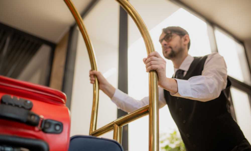 Hotel worker pushing luggage trolley