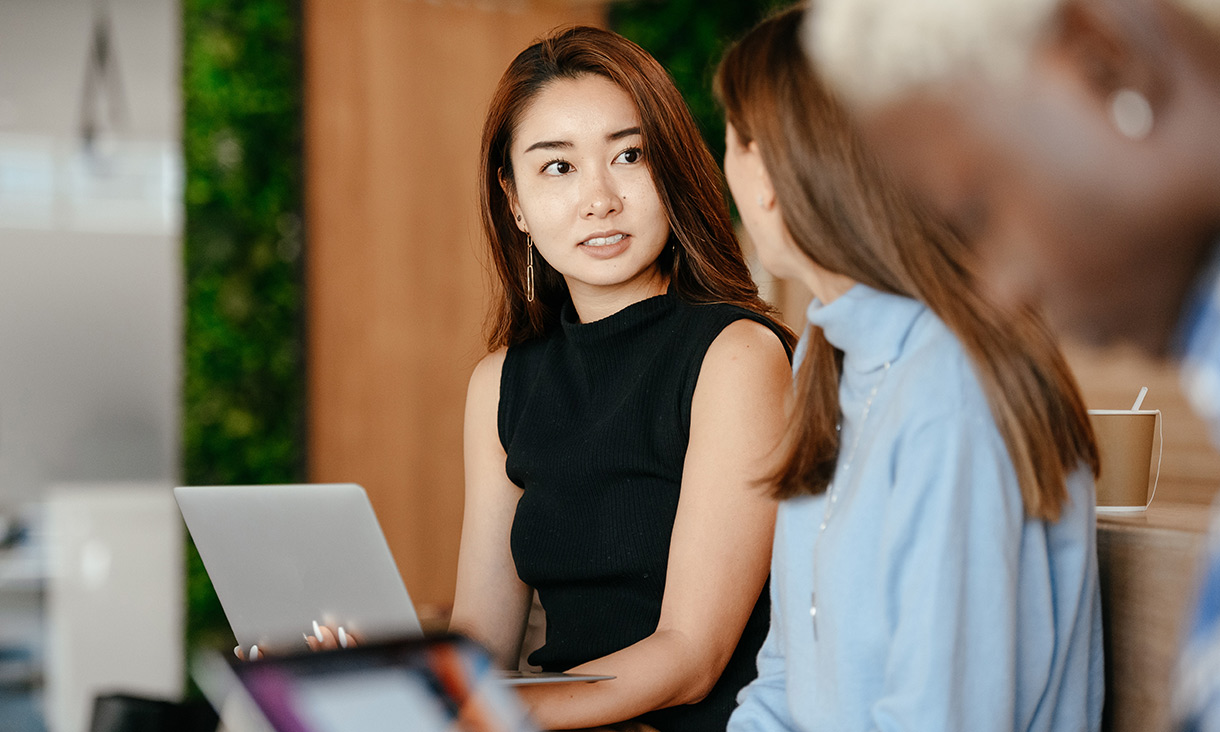 Student talking to advisor, facing each other while smiling 