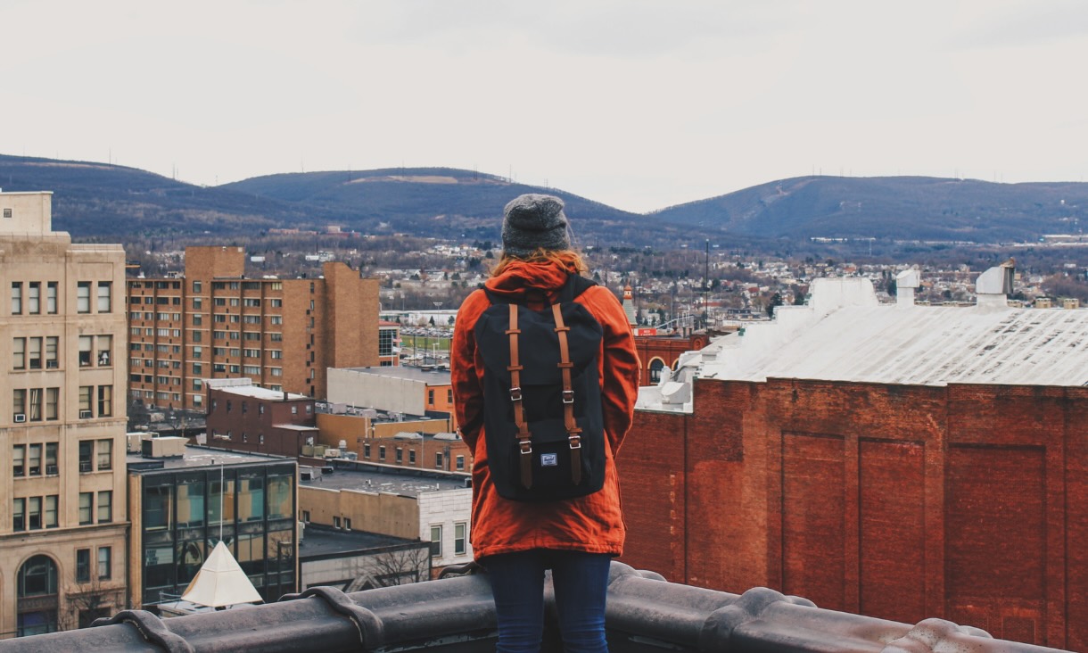 Student standing on a rooftop overlooking cityscape