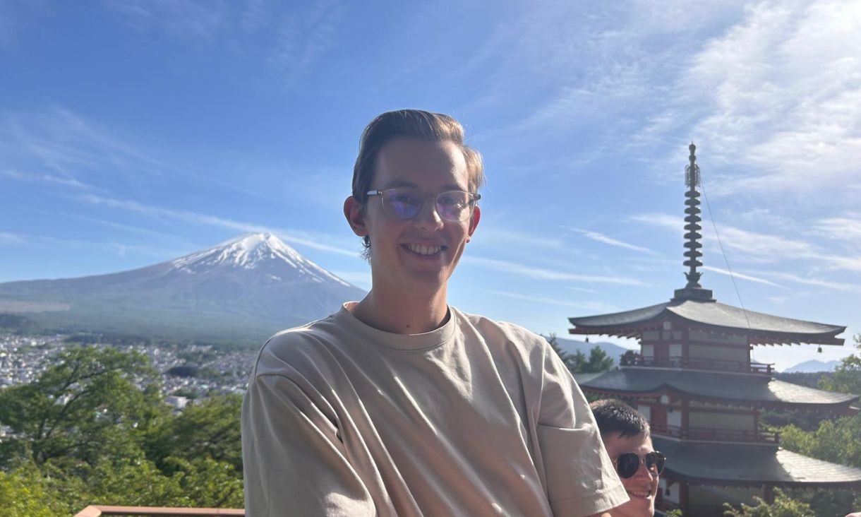 Max poses for a picture with Mount Fuji in the background. 