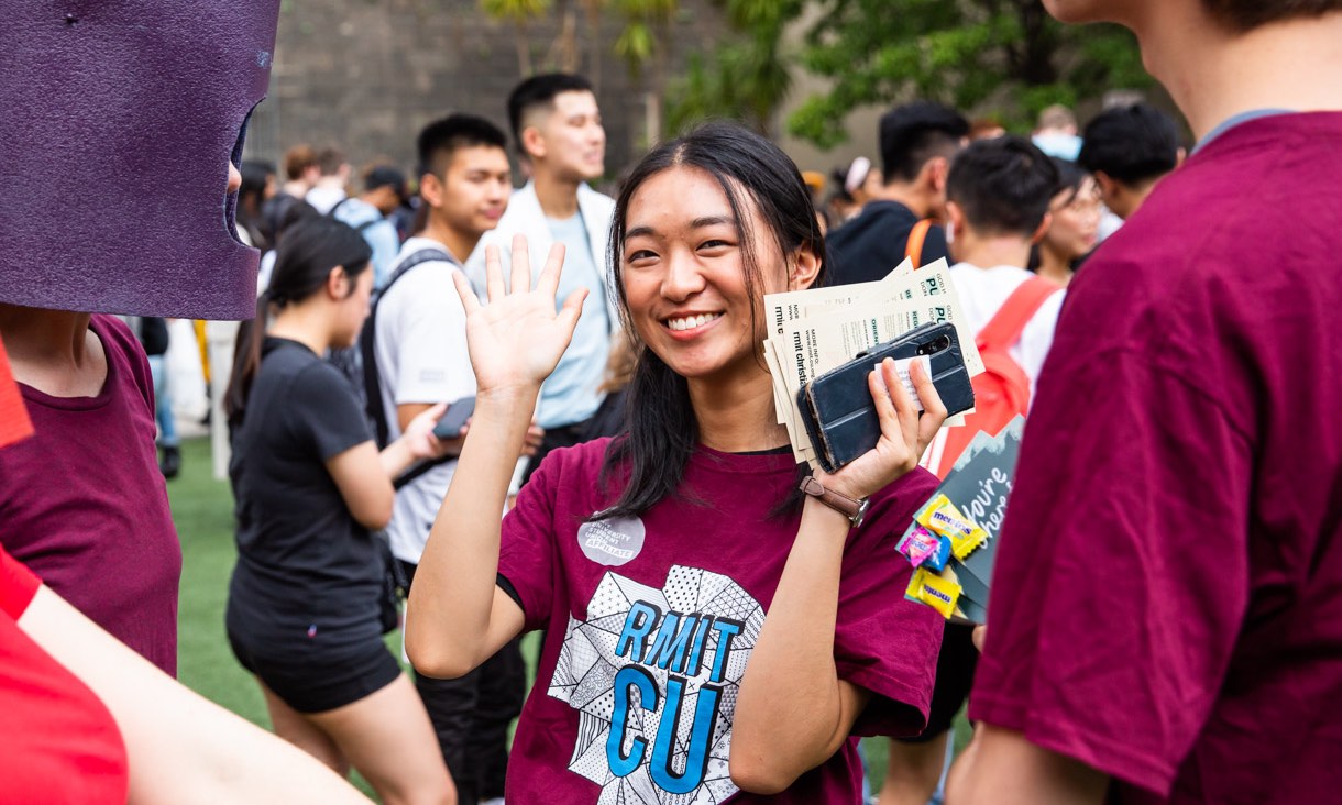 A student waves at the camera during an event at the City campus.