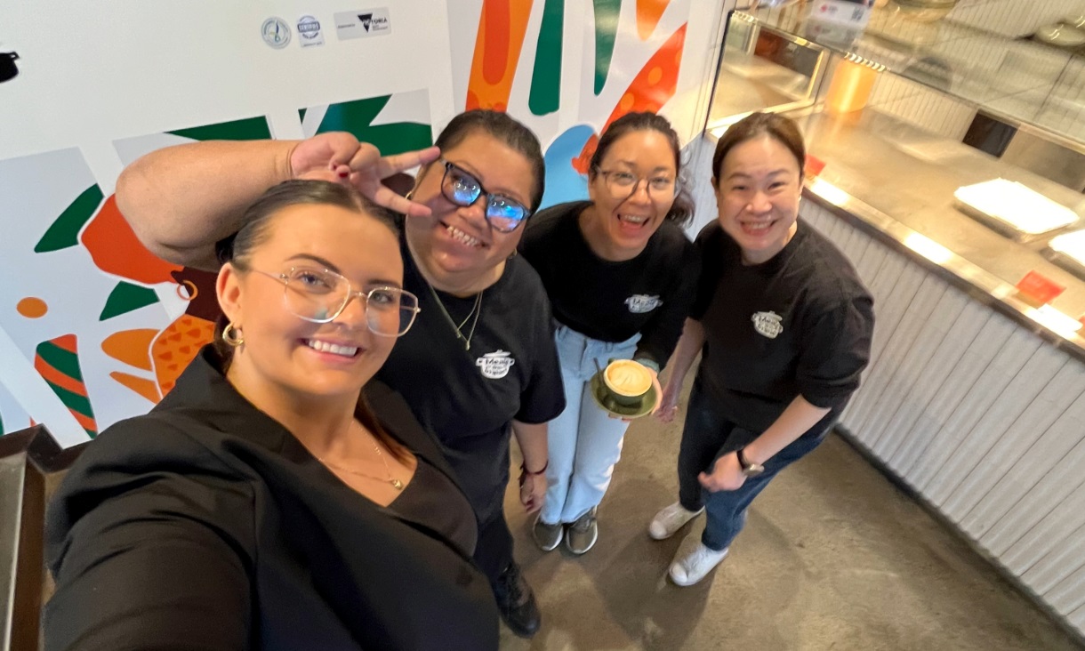 A woman takes a selfie with three other women.