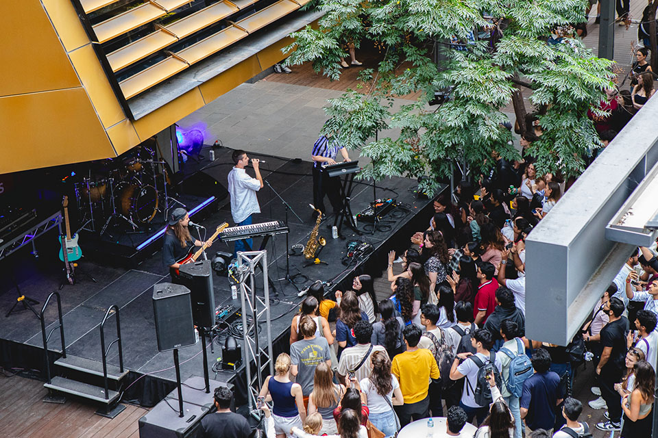 A band plays on stage in front of a crowd.