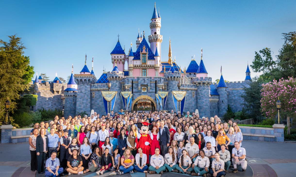 People posing in front of a Disneyland castle