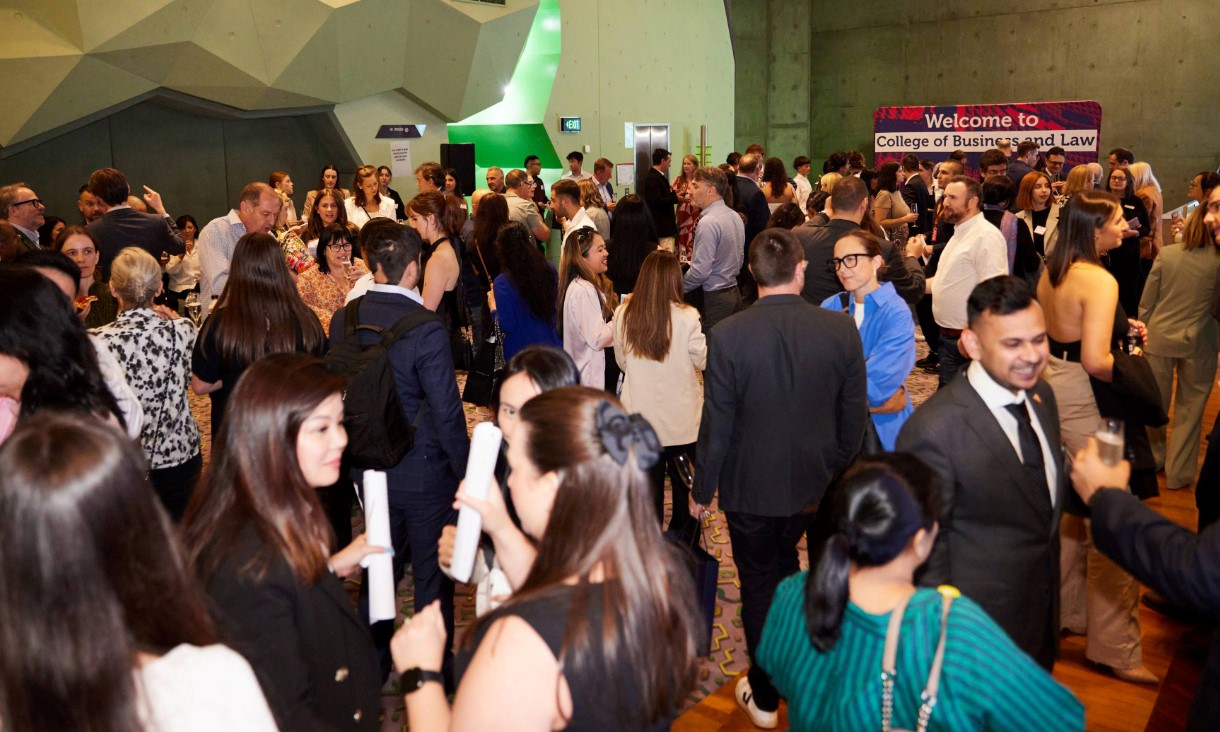 Large crowd of people gathered in a hall.