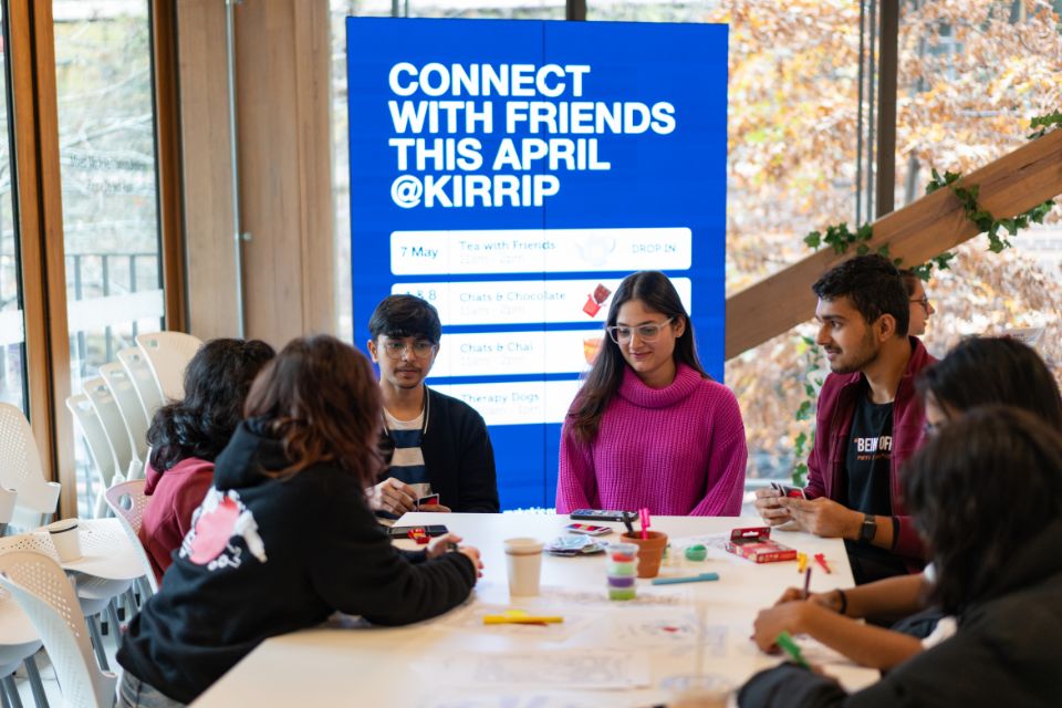 Students sitting around a table having a chat.