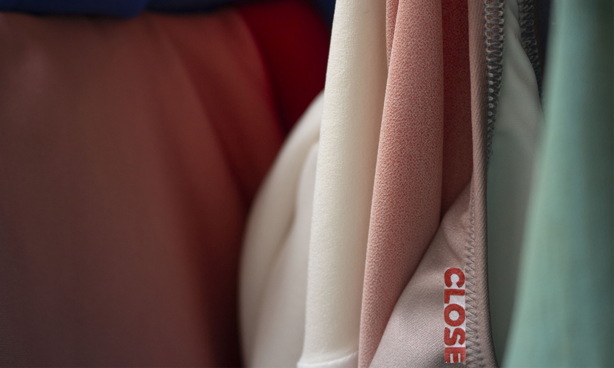 A close up of red, pink, white, and green fabric. The word "CLOSE" is stitched in red fabric in the bottom right of the image.