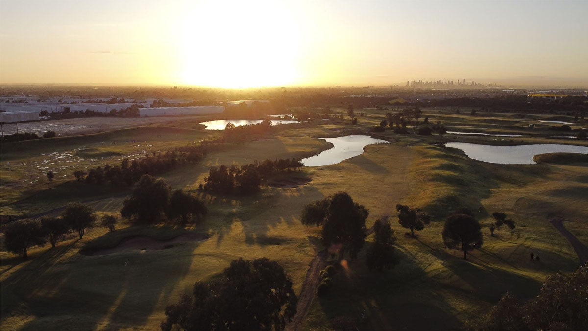 A landscape photograph of a golf course at sunset.
