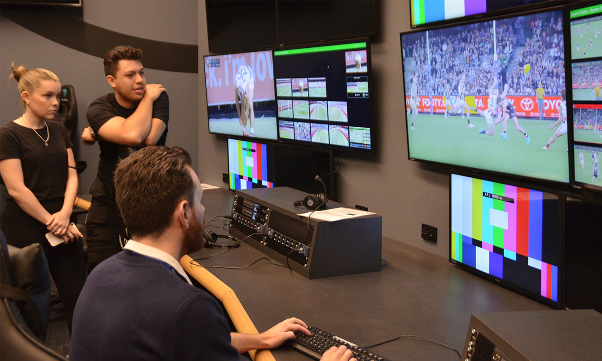 3 RMIT students work the Data Game control room for an AFL game.