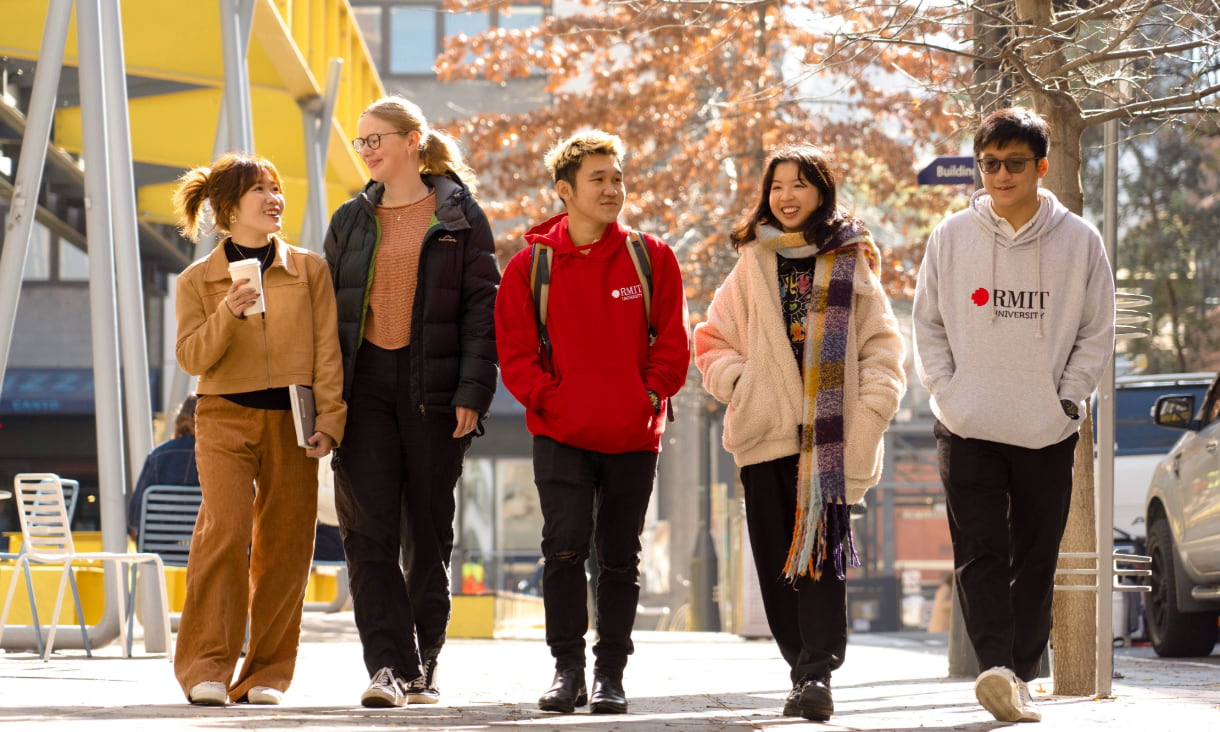 Line of five students walking on Bowen street with leafy background