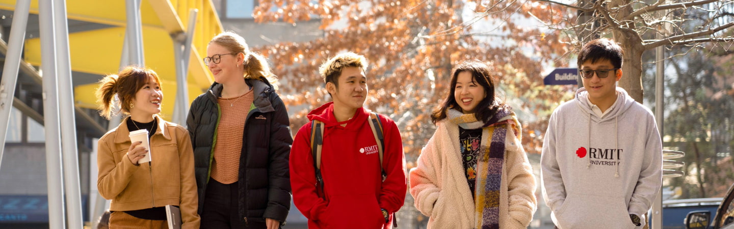 Group of students walking on Bowen Street lined with trees in the background