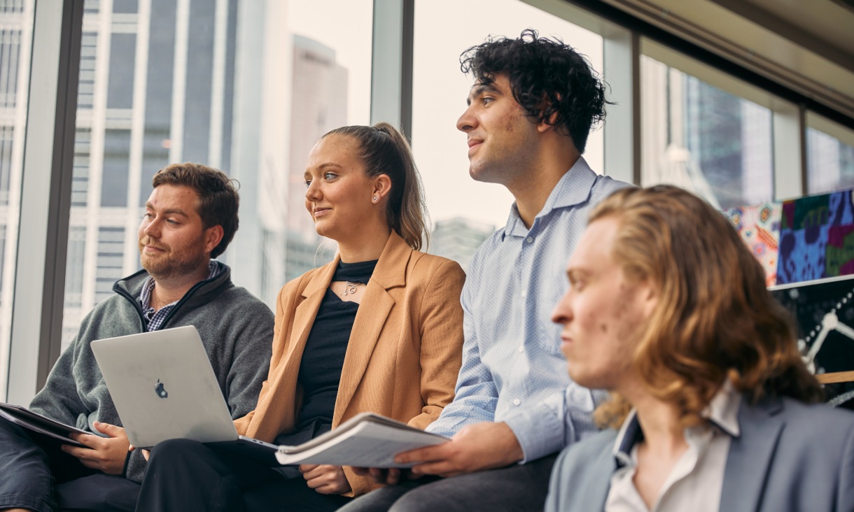 Four postgraduate students work together in a lecture theatre in the RMIT City campus