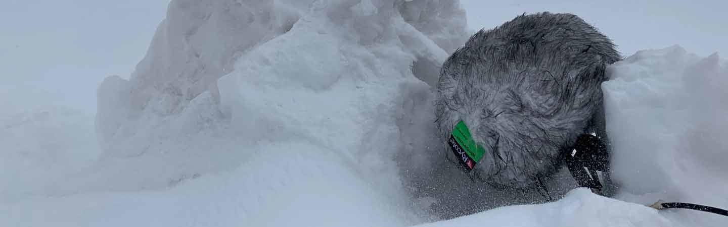 Microphone resting on ice next to a pile of snow.