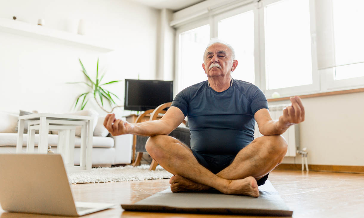 Older man doing yoga online