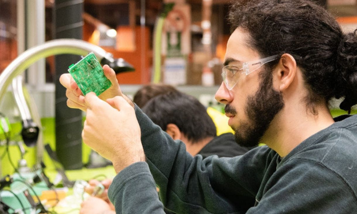 Mechanical engineering student inspecting widget.