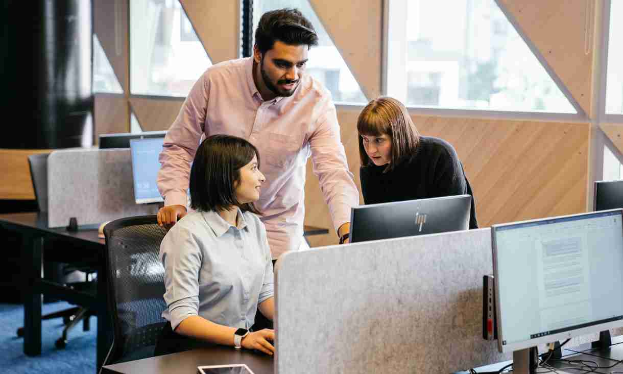 Three students gathered around computer.