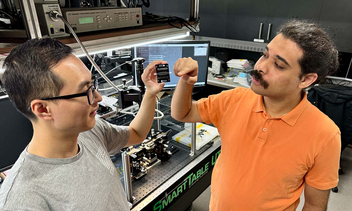 PhD scholar Yang Yang (left) and Dr Akram Youssry from RMIT with the team's reprogrammable light-based processor. Credit: Will Wright, RMIT University