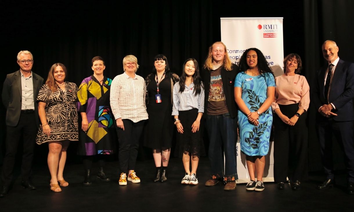 Group photo of speakers on stage in front of black backdrop