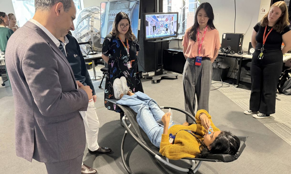 Head of the Australian Space Agency, Enrico Palermo (left), Dr Julia Low (third from the left) and PhD scholar Grace Loke (second from the right) observe a volunteer sitting in a microgravity-posture chair in the Virtual Experiences Laboratory (VXLab) at RMIT. Credit: Will Wright, RMIT University