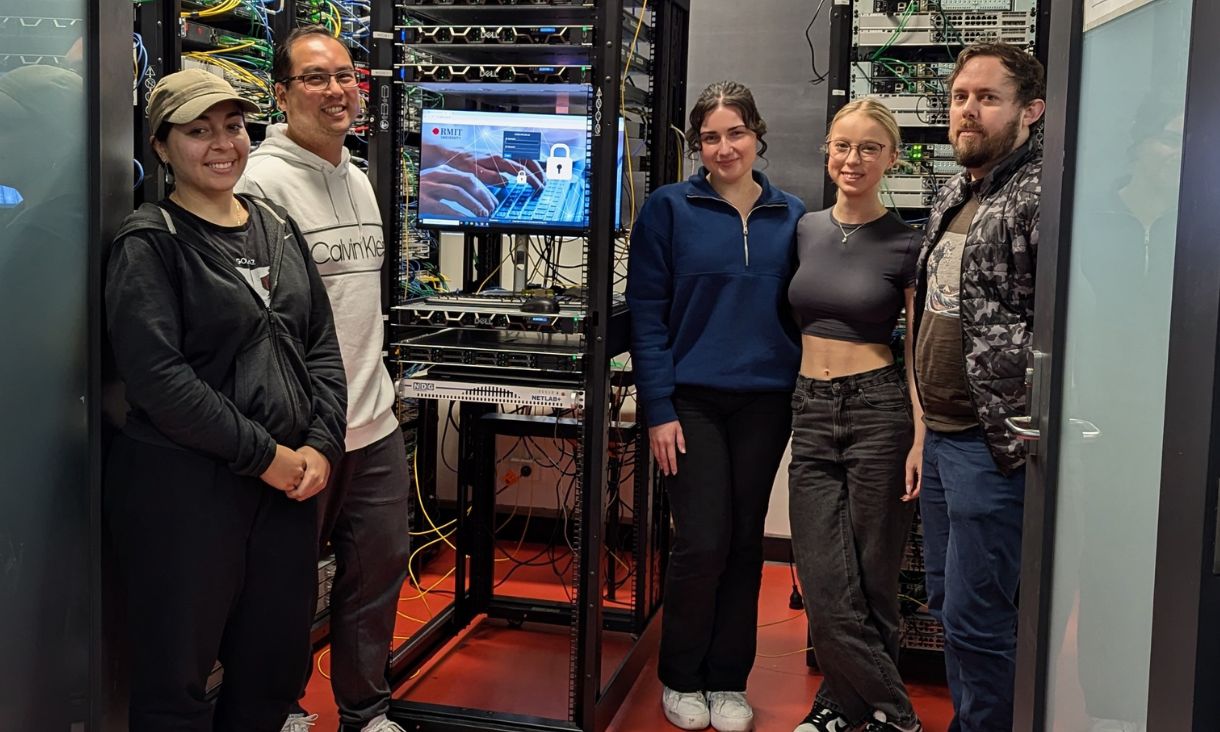 Students standing next to supercomputer.