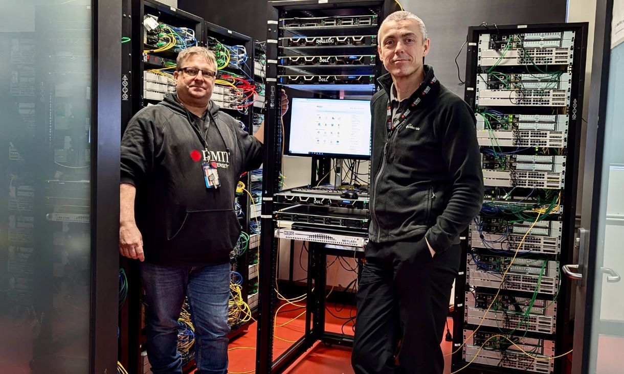 VE teacher Michael Barton and Luke Eberbach posing next to supercomputer