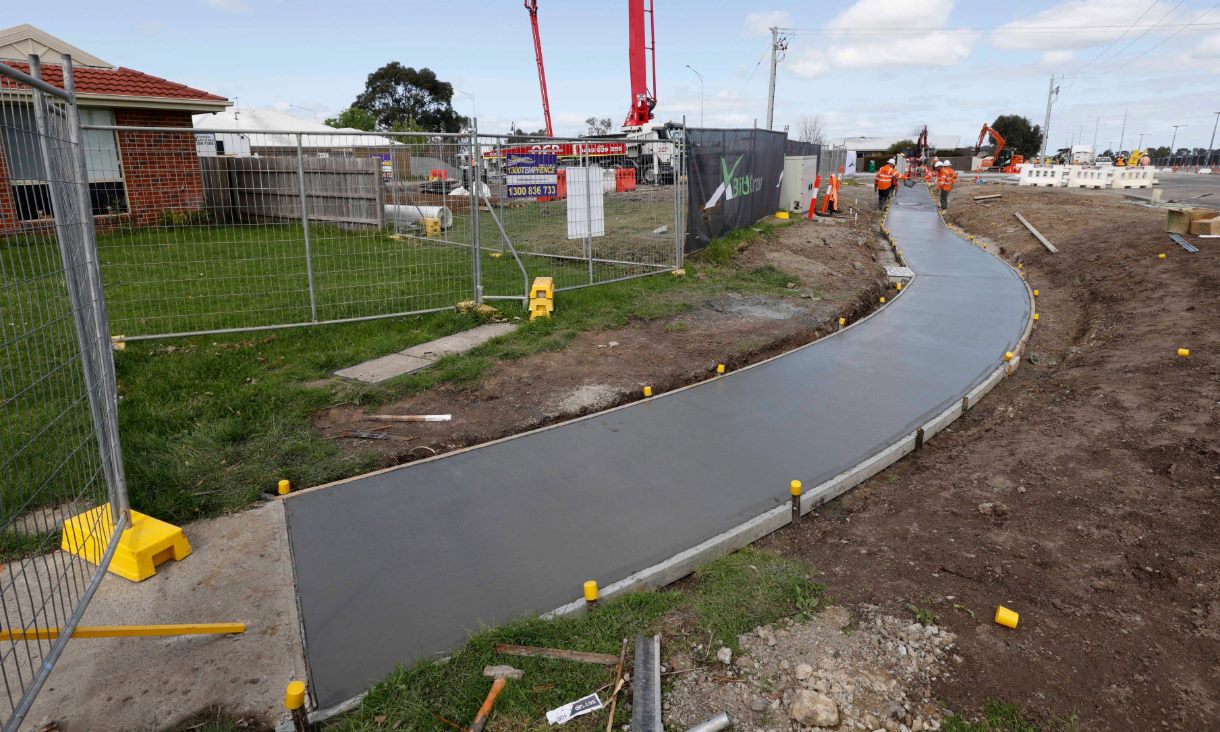 Coffee concrete footpath being laid along a busy road in Pakenham. Credit: Pete Glenane, HiVis Pictures