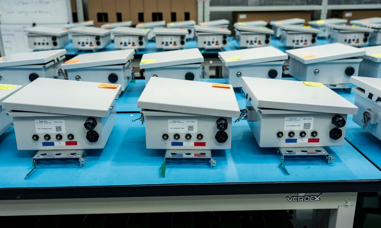 Four rows of electronic devices at a manufacturing facility.