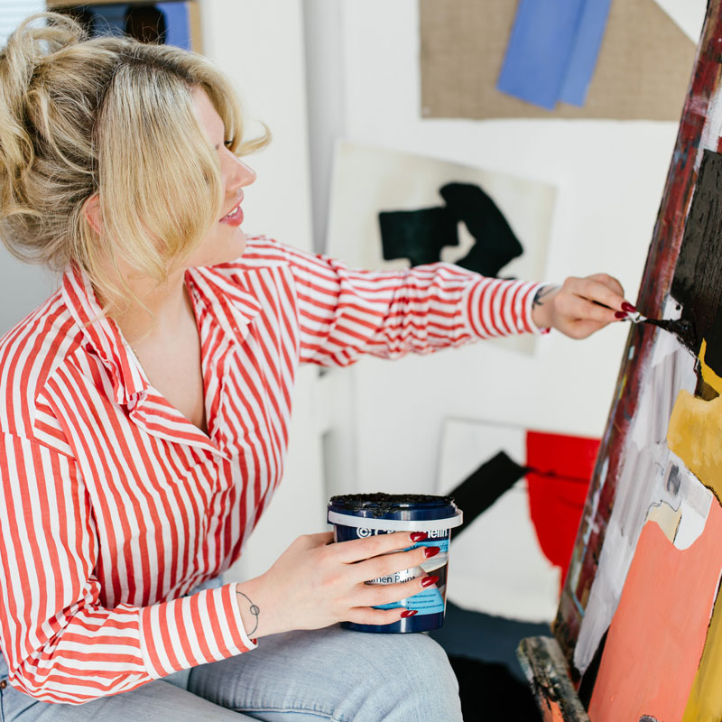 Student Olivia Morris painting in art studio